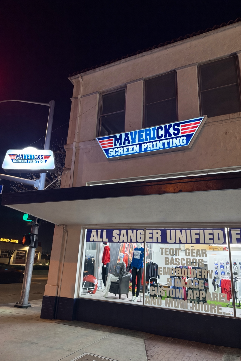 Mavericks Screen Printing storefront in downtown Sanger at night