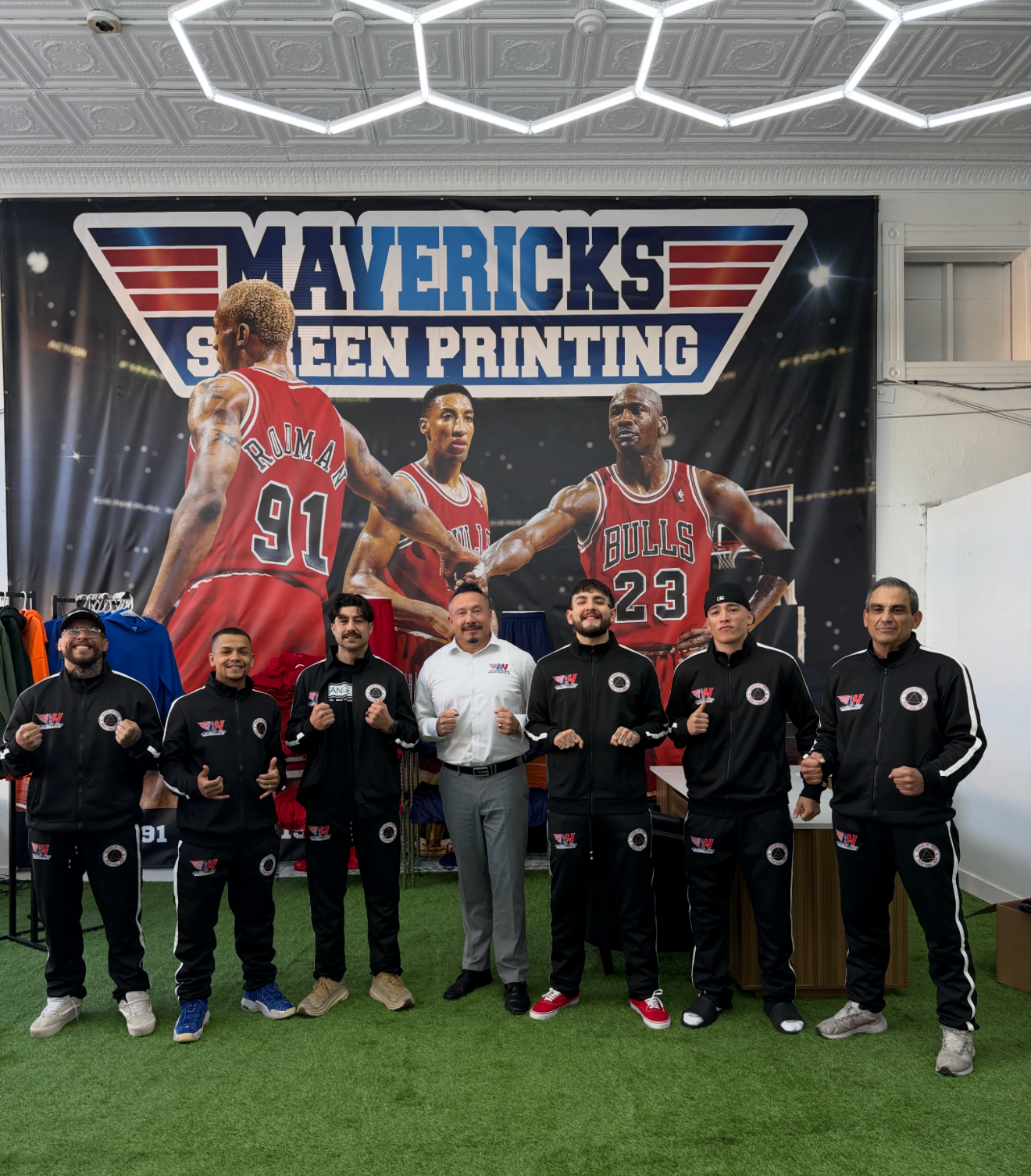 Mavericks Screen Printing team in front of custom Bulls banner